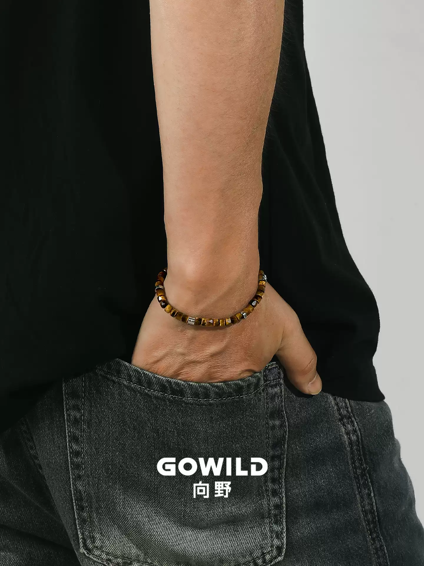 Golden tiger eye bracelet worn with a black shirt and denim