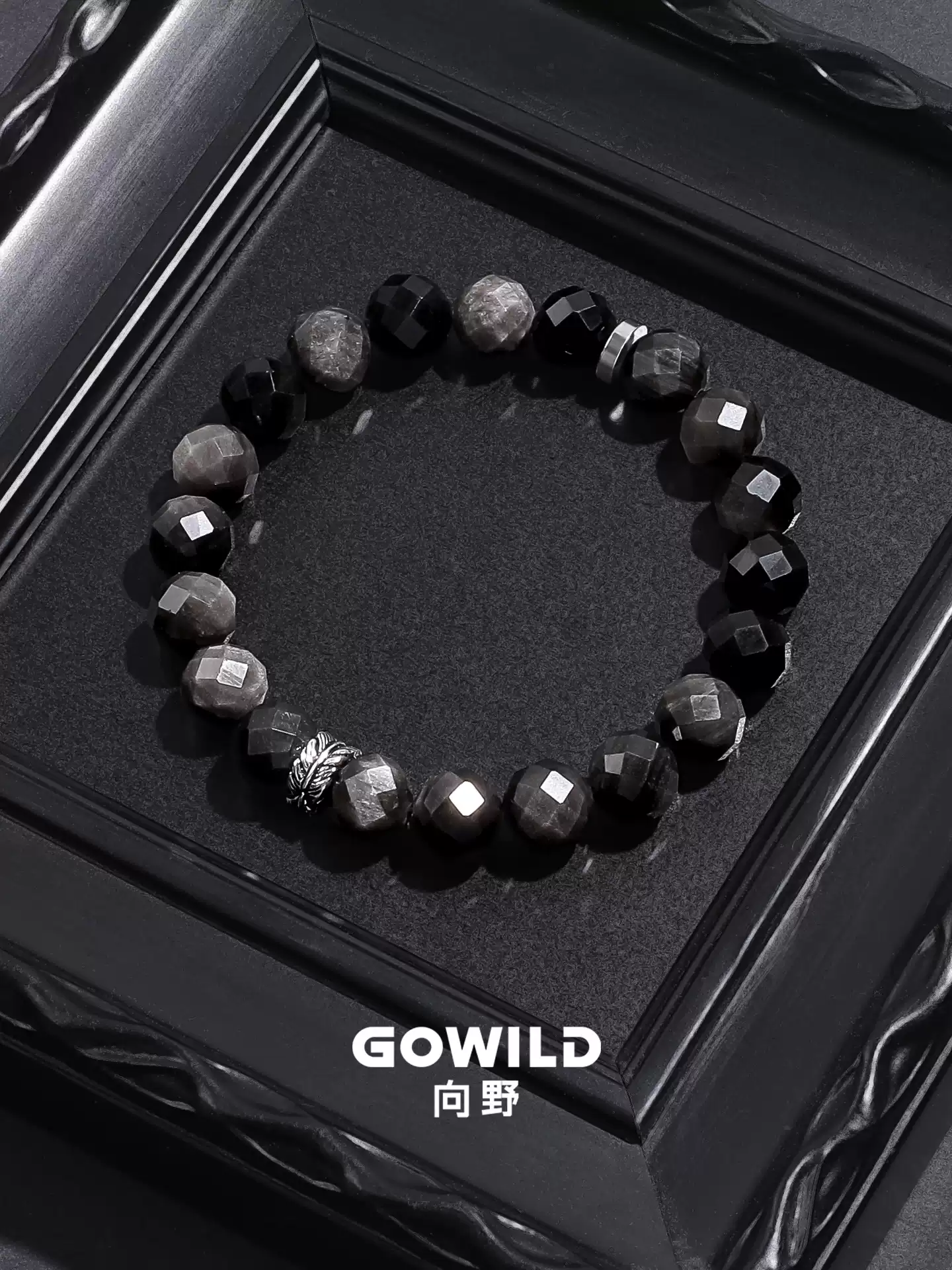Faceted silver sheen obsidian bracelet on a dark textured surface